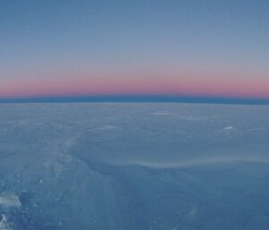 A beautiful light in the sky as night comes up over the horizon.