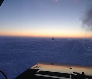 View from the front of a tractor on snow.