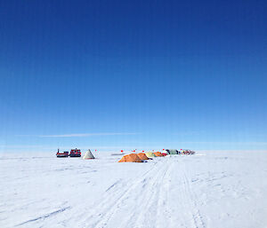 Hägg and tents on the ice with blue sky.