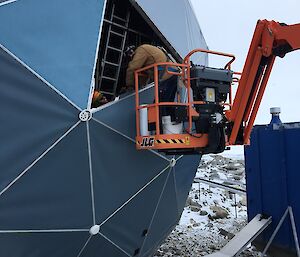 Scottish repairing the ANARESAT building in a elevated platform.