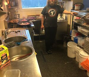 An expeditioner standing in the kitchen at Wilkins preparing food.
