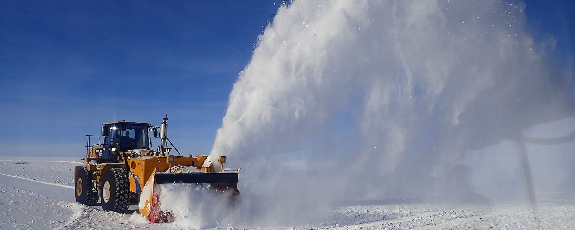 Machinery out on the runway blowing snow off it.