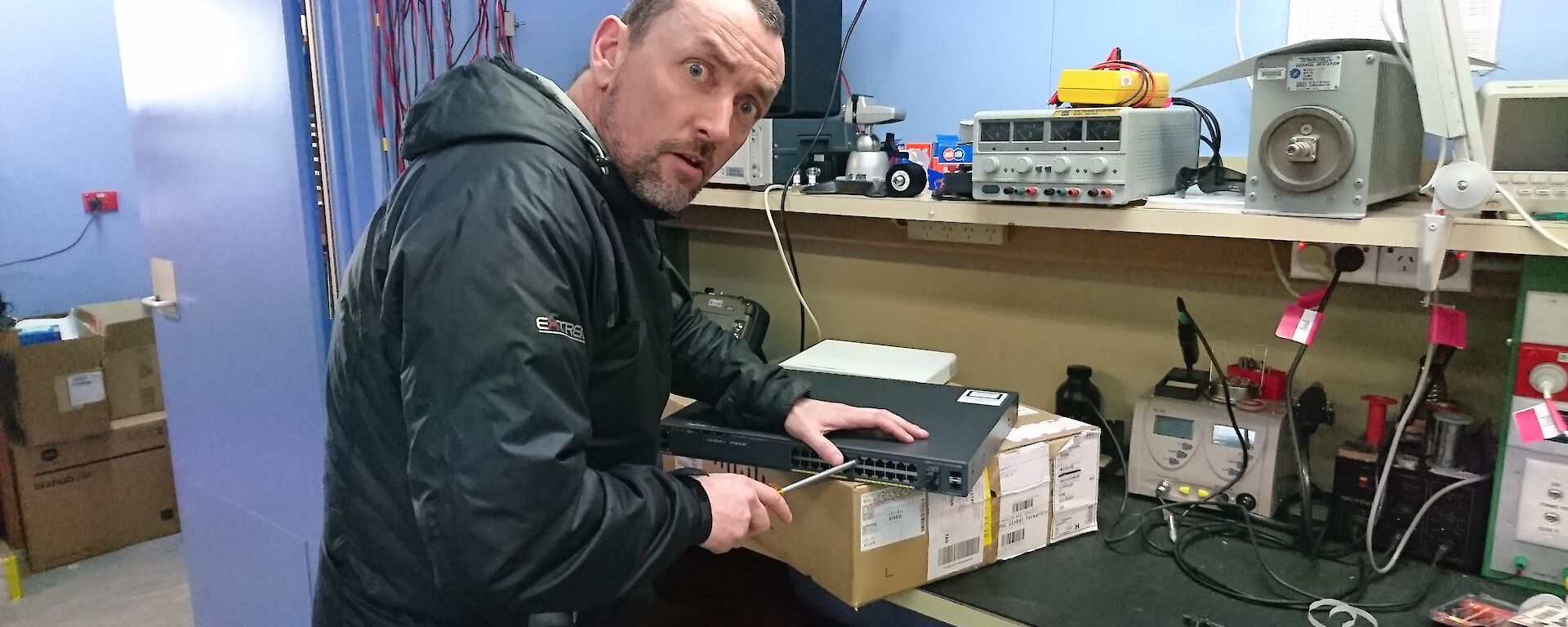 Stu with screw driver working on a bench.