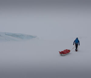 Expeditoner with sled on sea ice.