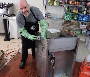 Andrew cleaning the deep fryer in the kitchen.