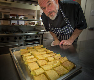 Andrew the chef in the kitchen with a tray of egg rolls