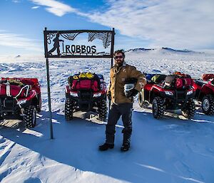 Zac standing with quad bikes.