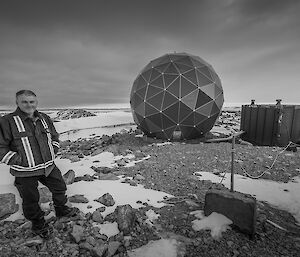 Expedition stands to left of picture with large communications dome in centre. Black and white image.