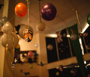 Looking up into the ceiling, balloons and masks hanging down.