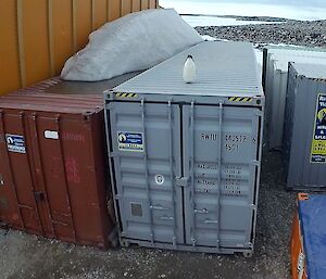 Adelie penguin on top of a grey shipping container