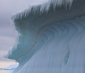 Close up of mushroom topped berg with icicles along upper edge