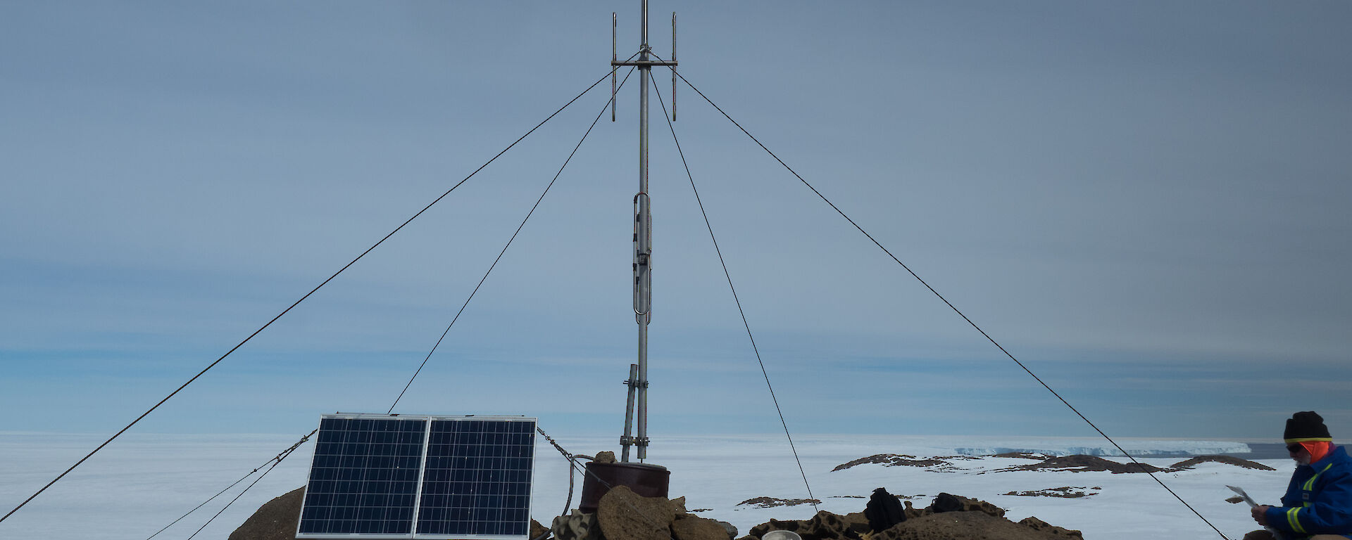 Rocky foreground, antenna in centre with four guide lines running out and solar panel at front left