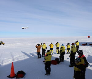 Group of expeditioners taking a photo of the plane arriving on the ice runway