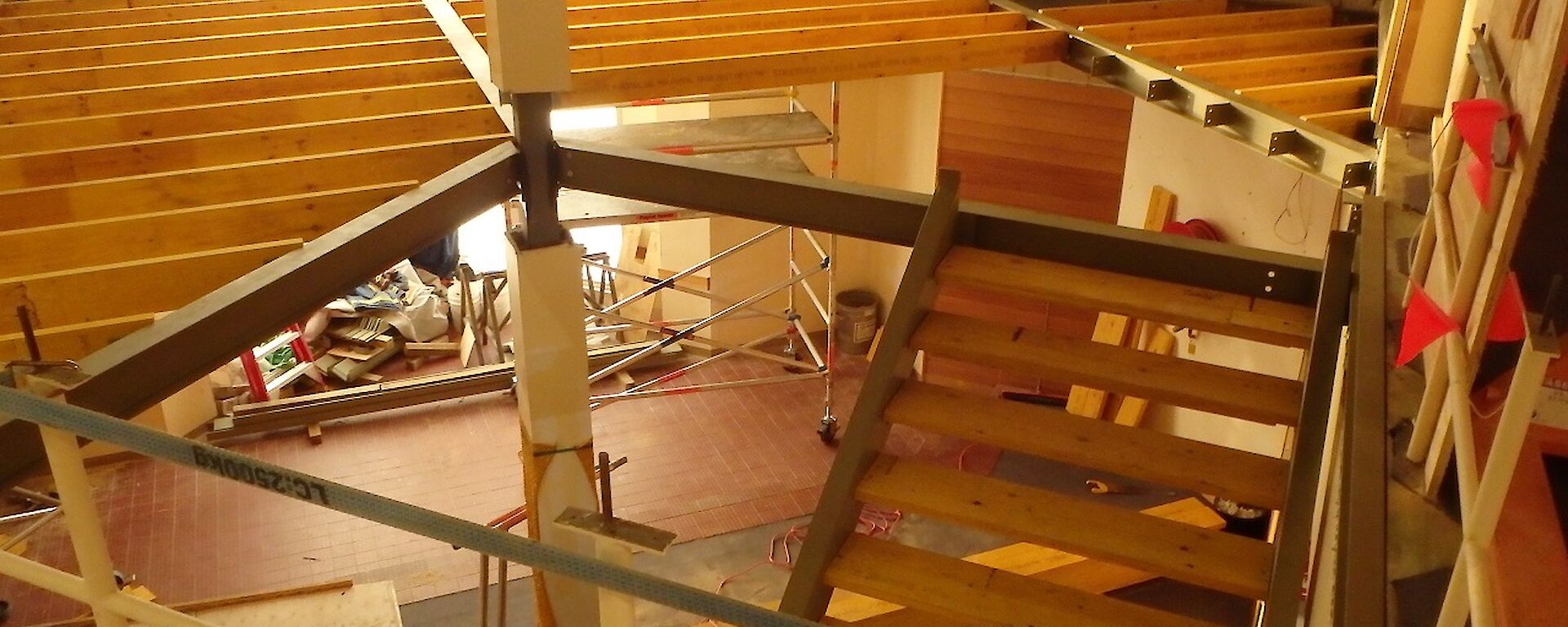 Large two story high internal space, being infilled with floor at mid level. Metal beams installed and floor planks infilling the space