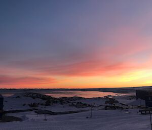 Overlooking station and newcomb bay to the ice platau with the sun rising creating purple and pink shading on the snow covered landscape
