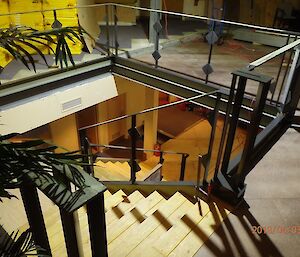 Looking down on a wooden staircase with metal balustrade which is freshly painted in a graphite grey colour