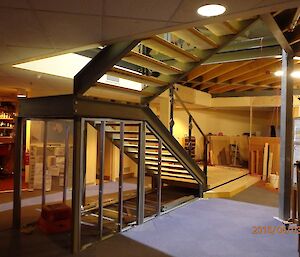 Underside of stairs, showing frame of understair storage, wooden treads and grey metal frame