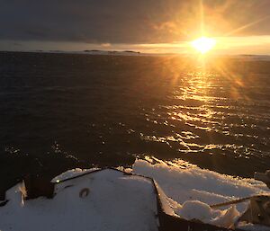 Picture taken from edge of the wharf towards the setting sun on other side of the bay, shows expanse of open water