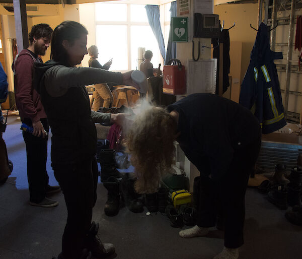 Woman putting talcom powder through hair or person bent over