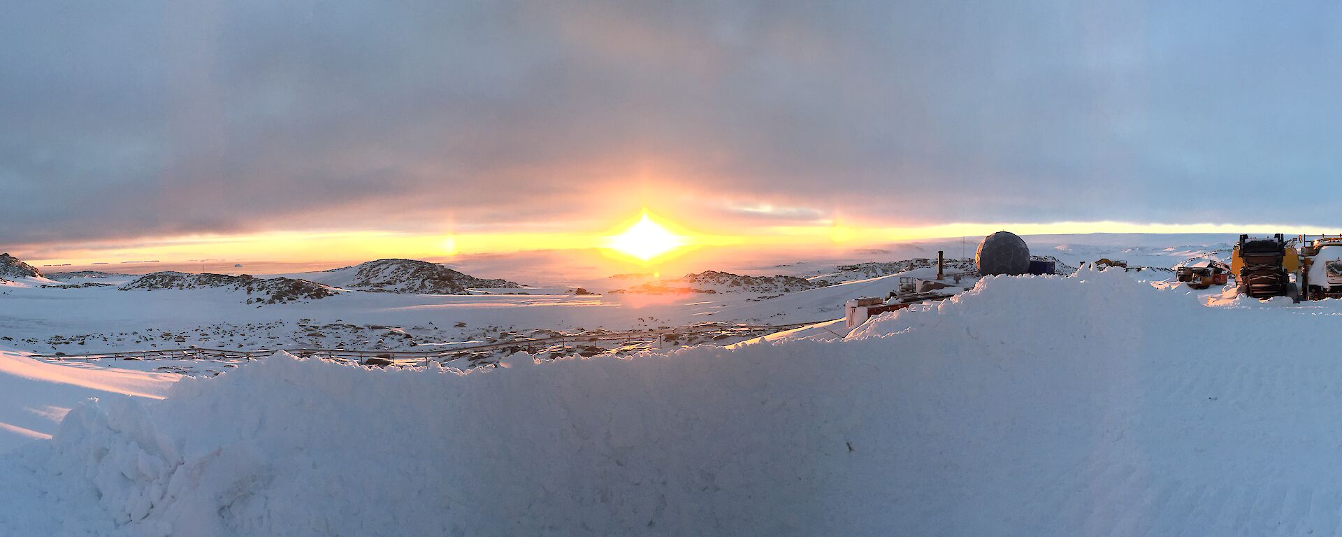 Panoramic photo overlooking Newcomb bay at sunrise with atmospheric conditions making sundogs either side of the sun rising