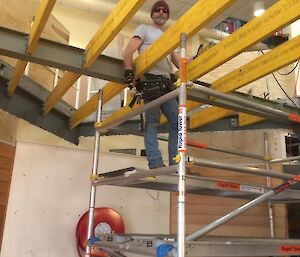 Man standing on scaffolding, building floor into mazzanine