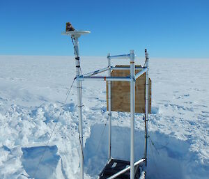 Square of metal scaffolding positioned in square hole in ice