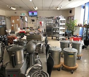 A long table in the mess covered to overflowing with kitchen equipment