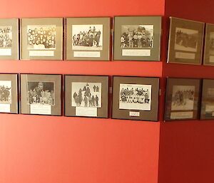 Long orange painted wall with two long strips of photos showing groups in black and white