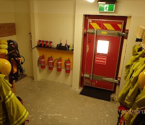 Vestibule to outside door, showing fire equipment hanging on hooks along wall