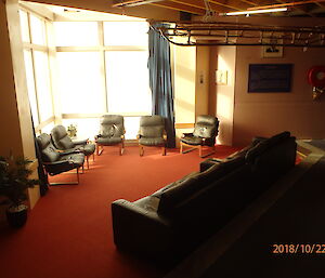 Lounge area with large corner windows, lounges and orange carpet