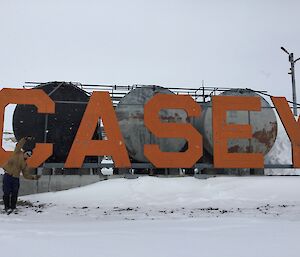 Matt standing in front of the Casey sign, in the shape of a ‘C'