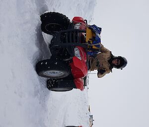 Mitch riding a quad in the snow
