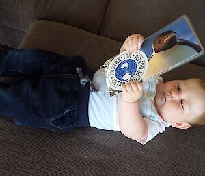 Holden (8 months) holding post cards from Antarctica