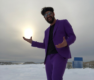 Chris dressed in purple suit standing on the snow
