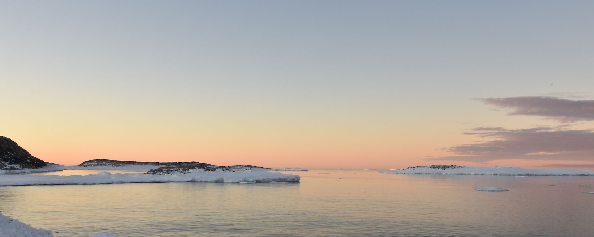 Sunset over the water and snow
