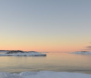 Sunset over the water and snow