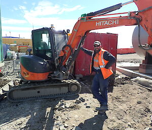 Plant operator standing beside a mechanical digger