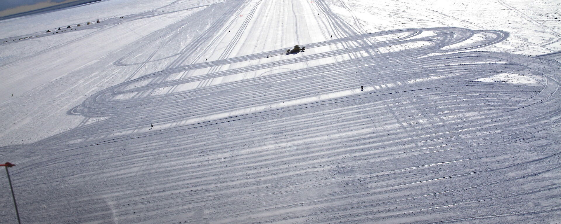 Ski grooming vehicles working across a ski landing area on the plateau above Davis