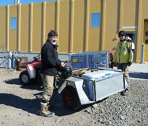 Expeditioner facing camera in front of yellow science laboratory at Davis station