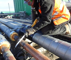 Tradesmen cutting copper pipe with reciprocating saw