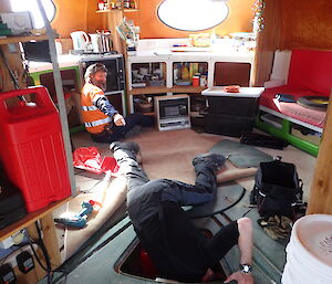 Two tradesmen working inside a hut