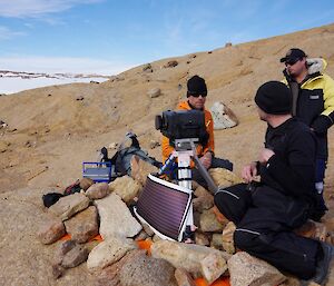 Expeditioners inspecting camera equipment