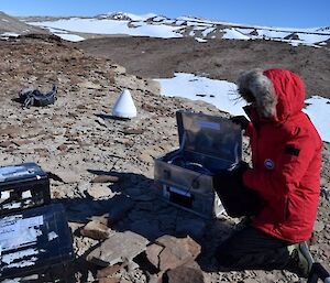 Expeditioners with GPS unit mounted on rocky outcrop