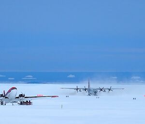 C130 cargo aircraft taxiing past another aircraft on the ski landing area at Davis