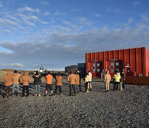 Expeditioners gathered in front of a heli-pad waving goodbye to departing Indian delegation