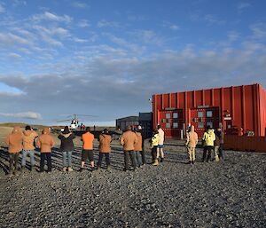 Expeditioners gathered in front of a heli-pad waving goodbye to departing Indian delegation