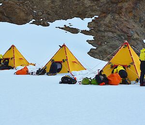 Expeditioners beside polar pyramid tents
