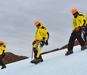 Expeditioners walking slowly down steep icy terrain