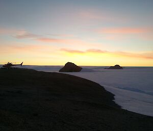 Helicopter in foreground, sunset in background