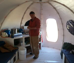 Expeditioner standing inside new hut